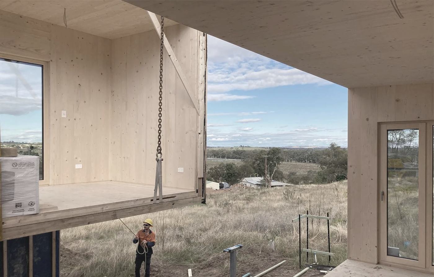 Cross laminated timber volumetric module being set by crane