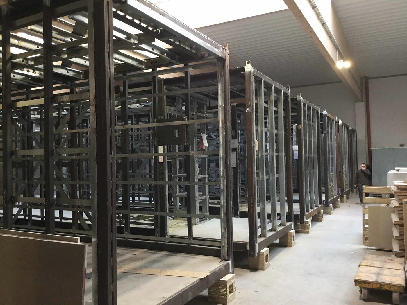 Steel-frame volumetric module chassis lined up on the factory floor